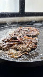 קציתות הסמאש בורגר עם בצל מקורמל במחבת הלוהטת