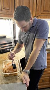 השף לירוי קפוזה מורח את המרינדה על הבשר - מתכון לפסטרמה