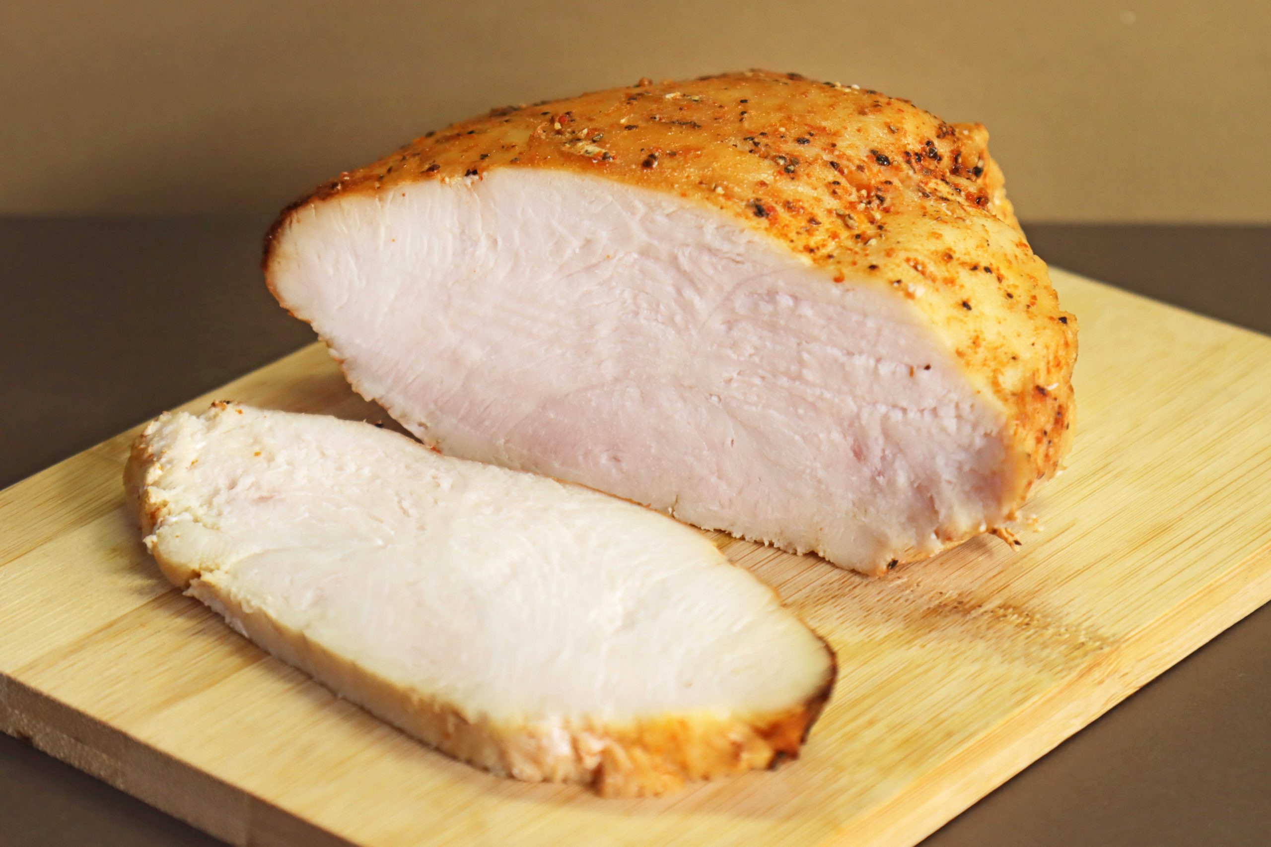 גוש פסטרמה הודו ביתית על מגש עץ, ולידה שוכבת פרוסת פסרטמה.