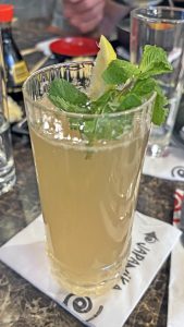 מוחיטו בכוס זכוכית גבוהה עם נענע, על גפי מפית של ג'פניקה