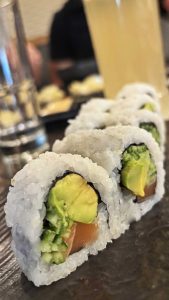 סושי ג'פנקו עם אבוקדו, סלמון ומלפפון על גבי צלחת שחורה