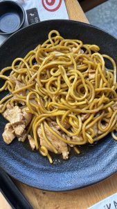 מנת פרש נודלס קידס עוף - ג'פניקה נודלס עם רצועות עוף על גבי צלחת שחורה