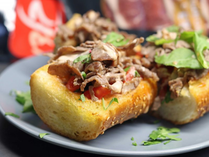 ברוסקטה אנריקוט על גבי בגט עם עלי רוקט, על גבי צלחת אפורה