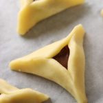 משולש אוזן המן לפני האפייה עם נוטלה על נייר אפייה