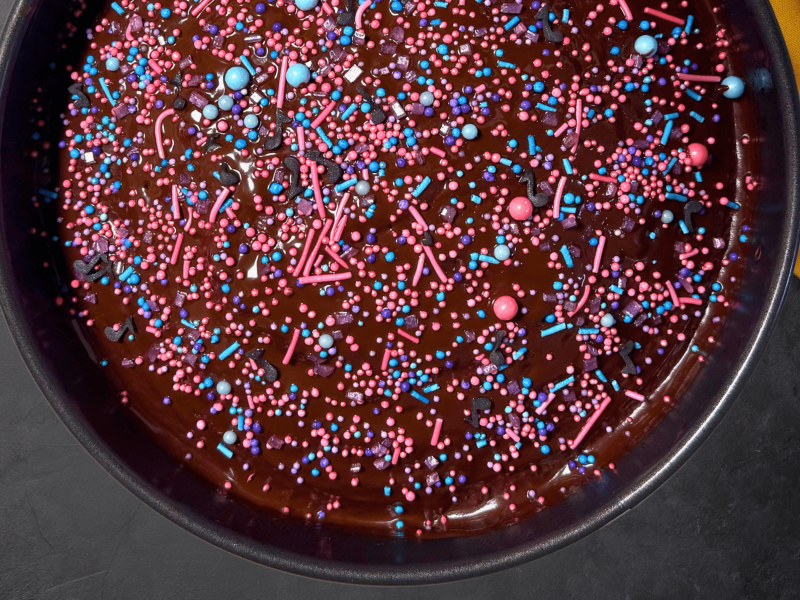עוגת שוקולד עם סוכריות צבעוניות על בד מבולגן כתום