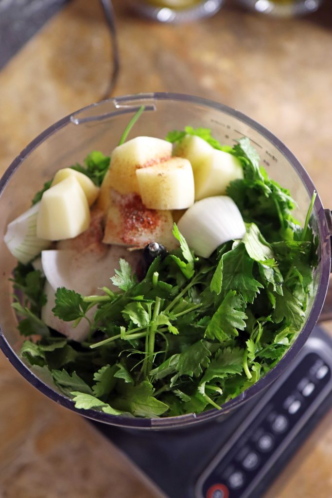 מרכיבי הפלאפל בתוך עבד המזון תפוח אדמה, שום, עשבי תיבול